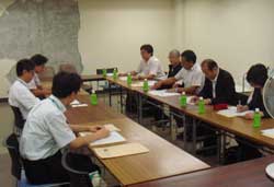 　壁のはがれた市役所会議室で説明を受ける訪問団
